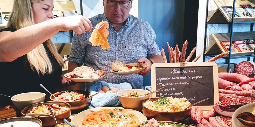 Koppel schept borden vol aan het buffet